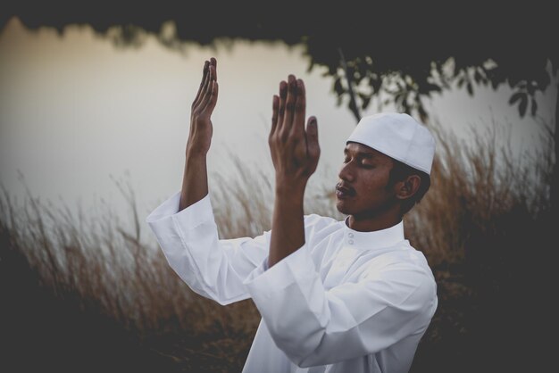 Silhouette Young asian muslim man praying on sunsetRamadan festival concept