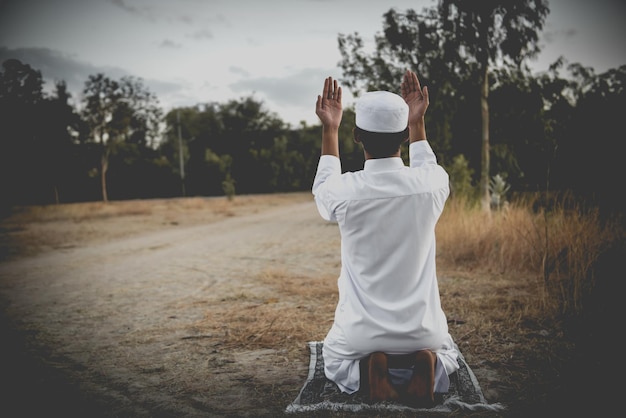 Silhouette Young asian muslim man praying on sunsetRamadan festival concept