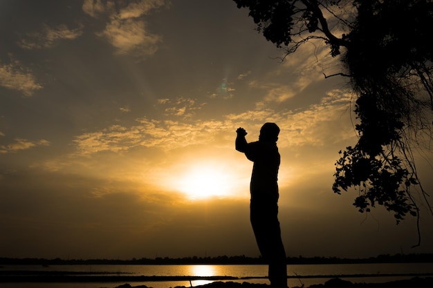 Silhouette Young asian muslim man praying on sunsetRamadan festival concept