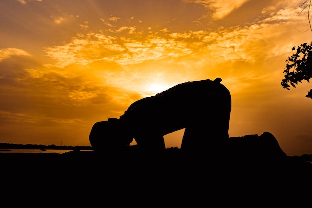 Silhouette Young asian muslim man praying on sunsetRamadan festival concept