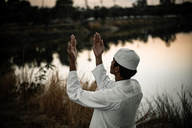 Silhouette Young asian muslim man praying on sunsetRamadan festival concept