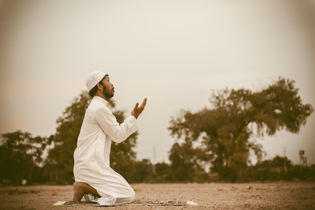 Silhouette young asian muslim man praying on sunsetramadan\
festival concept