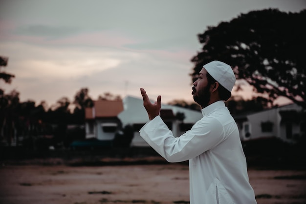 Silhouette Young asian muslim man praying on sunsetRamadan festival concept