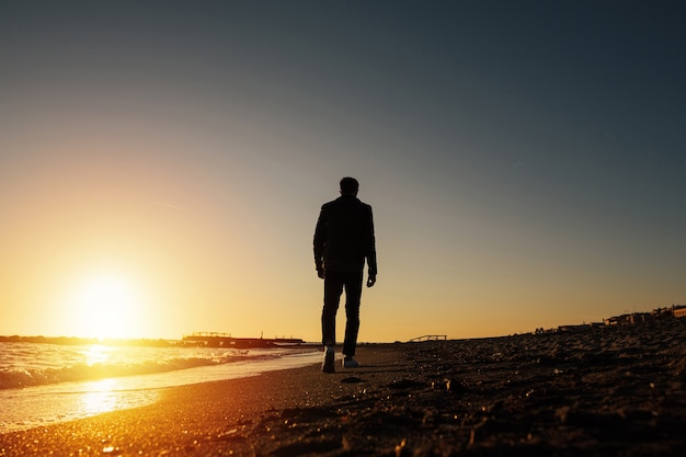 Silhouette of young man on the beach in Italy.