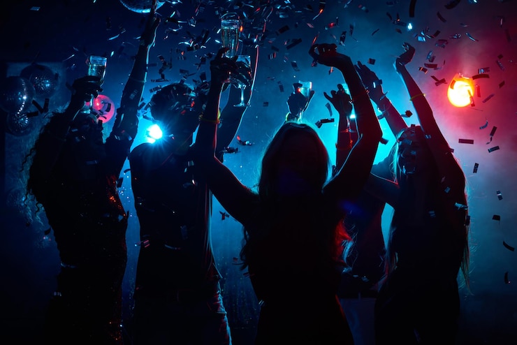 Photo silhouette of young people with raised flutes having fun and clubbing