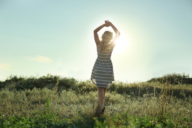 Silhouette of young woman on blue sky background