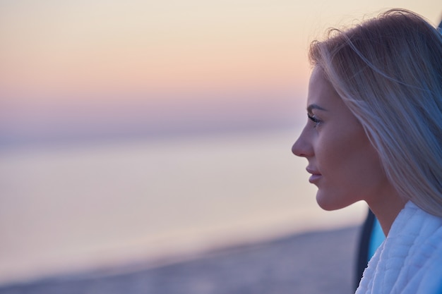 silhouette of young woman practicing yoga on the beach at sunrise