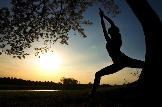 Silhouette of young woman practicing yoga outdoors