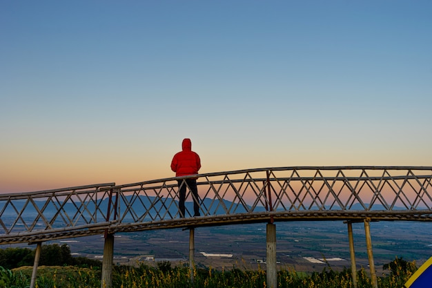 Silhouetted of Asian man standing on Bamboo bridge at Ban Doi Sa-ngo Chiangsaen, Chiang Rai Province, Thailand.