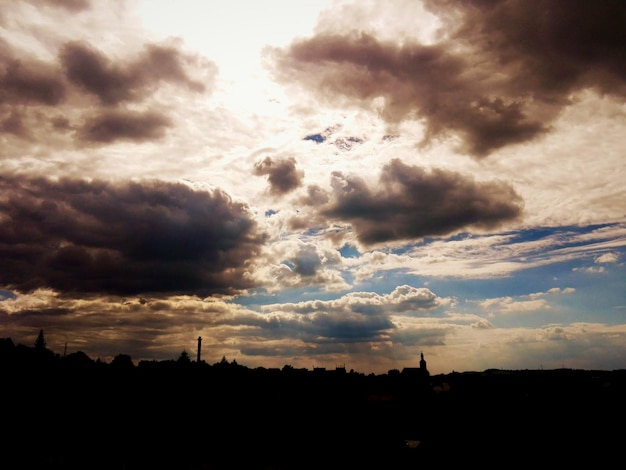 silhouetted buildings against cloudy sky
