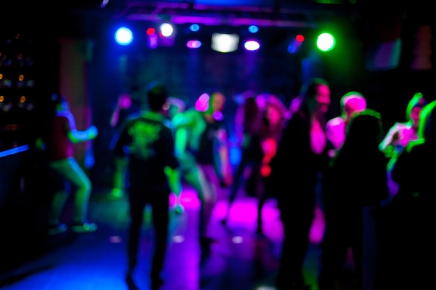 Silhouetten van dansende mensen in een club voor het heldere, schilderachtige lichtconcept van het nachtleven