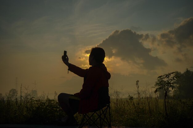 Silhouetten van mensen die foto's maken met uitzicht op prachtige groene rijstvelden op een zonnige ochtend