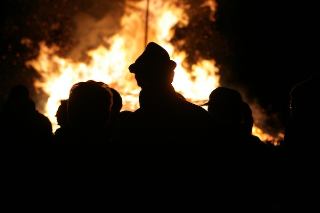 Foto silhouetten van mensen die's nachts bij een vreugdevuur staan