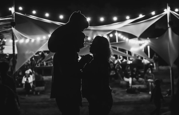 Silhouetten van ouders met een kind 's nachts op het festival