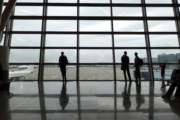 Silhouetten van passagiers die wachten op vertrek op de internationale luchthaven Vnukovo van Moskou