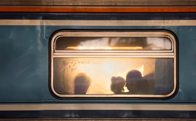 Silhouetten van passagiers in oude treinwagon