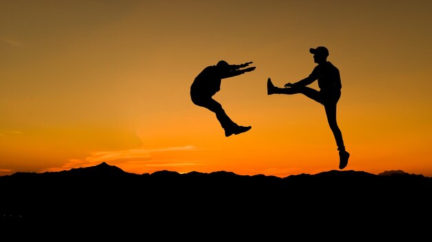 Foto silhouetten van twee mannelijke strijders op de achtergrond van de zonsondergang