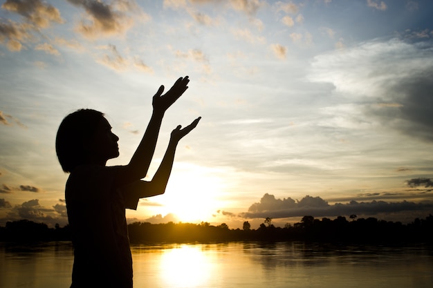 silhouetten Vrouwen bidden hand over mooie zon achtergrond instellen