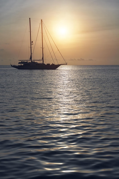 Foto silhouetten zeilboten op zee tegen de hemel tijdens zonsondergang