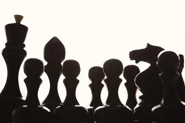 Photo silhouettes of black chess figures on white background, business and crowd concept, copy space