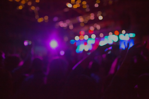 The silhouettes of concert crowd in front of bright stage lights. Concert of an abstract rock band