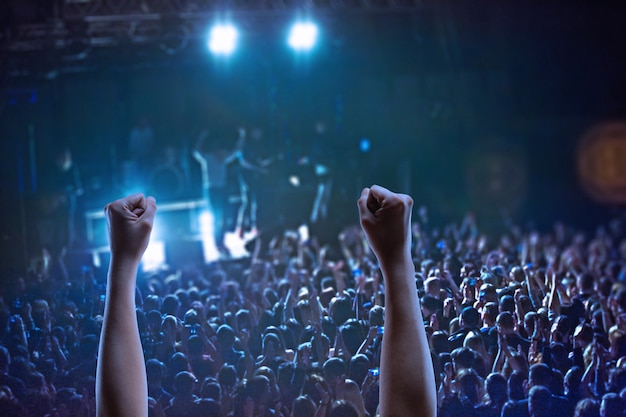 The silhouettes of concert crowd in front of bright stage lights. concert of an abstract rock band