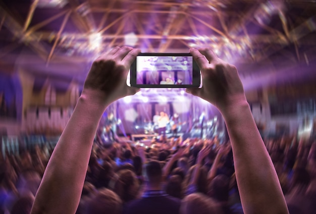 The silhouettes of concert crowd in front of bright stage lights. Concert of an abstract rock band