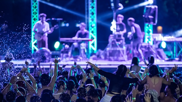 Foto siluette della folla di concerto davanti alle luci del palcoscenico luminoso, festa in piscina