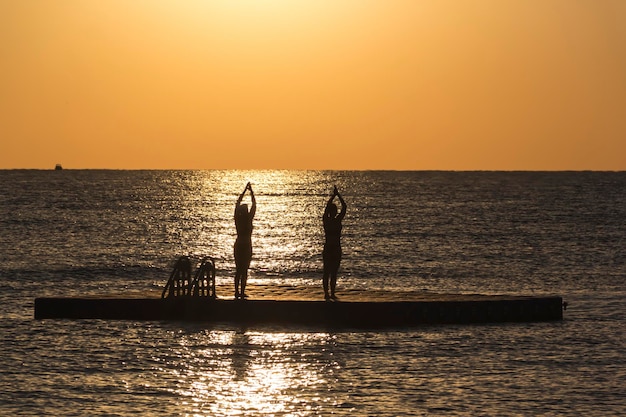 Silhouettes of figures of girls practicing yoga