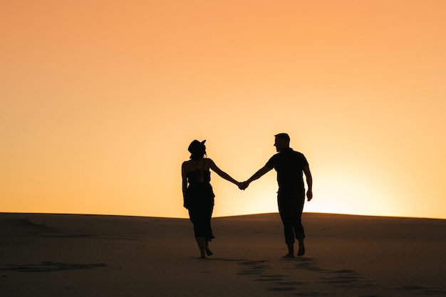 Silhouettes of a happy young couple guy and woman