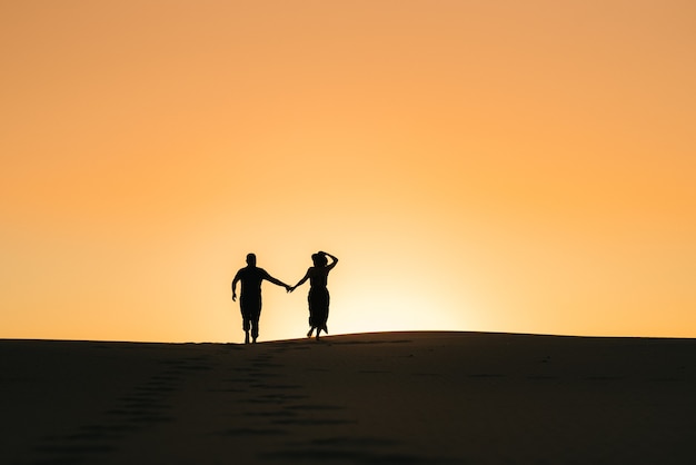 Silhouettes of a happy young couple guy and woman