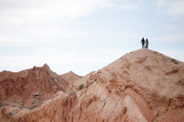 Silhouettes of loving couple on the top of the mountain