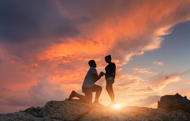 Sagome di un uomo che presenta una proposta di matrimonio alla sua ragazza