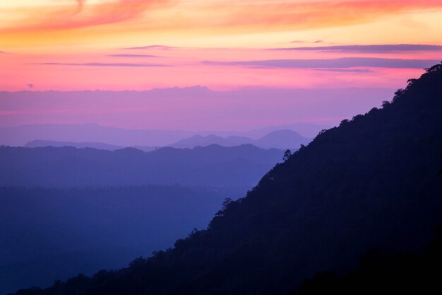 朝の霧の山の丘の層のシルエット。カラフルな夏の風景。