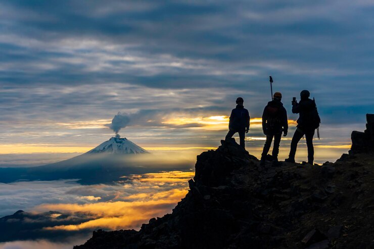 Photo cotopaxi 화산을 배경으로 해가 뜰 때 산악인의 실루엣