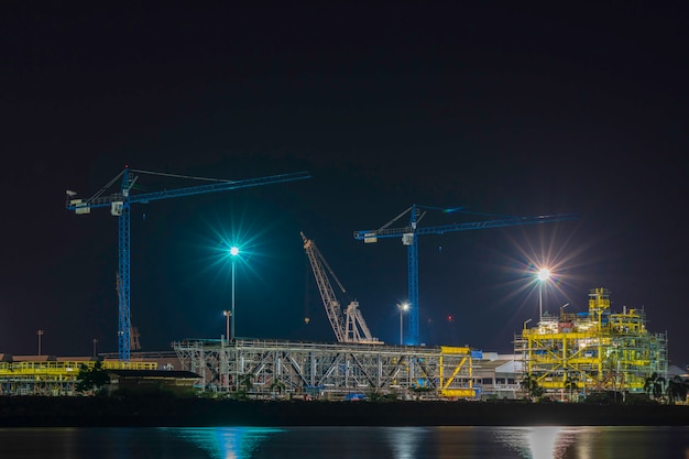 写真 夕方の空のクレーンのシルエット。建設業。