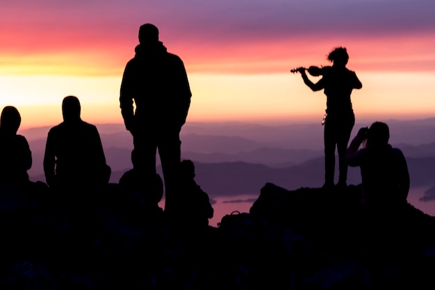 Фото Силуэты людей на вершине горы