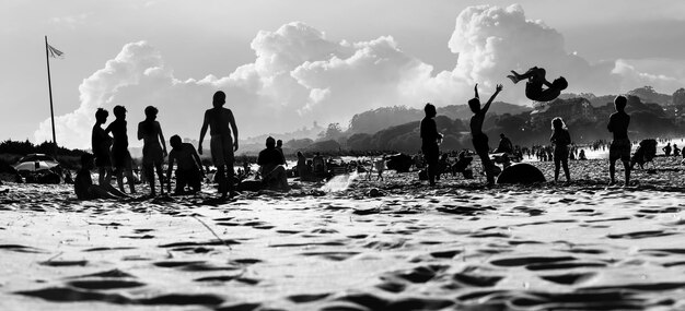 Silhouettes of people on the beach having a fun time on vacations on the coast