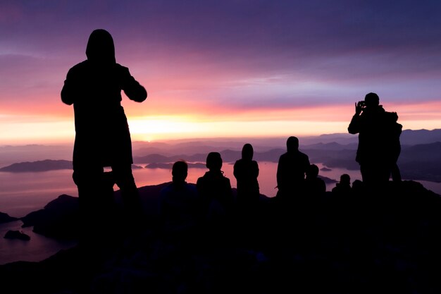 Foto sagome di persone in cima a una montagna