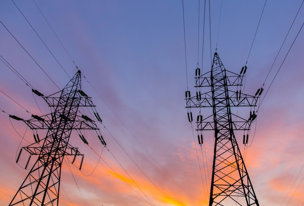 Silhouettes of power lines on a sunset. Bright orange urban sunset