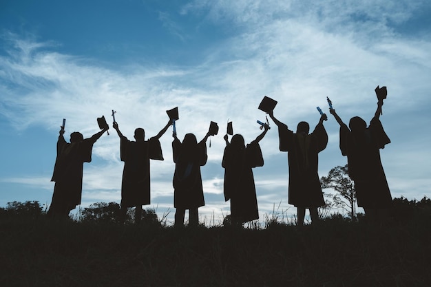 Silhouettes of students celebration education graduation\
student success learning concept ceremony at university