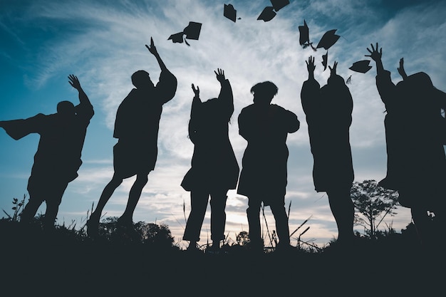 Silhouettes of students celebration education graduation\
student success learning concept ceremony at university