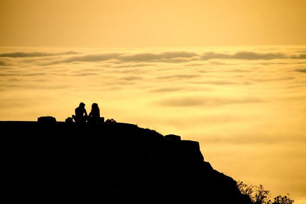 Силуэты двух человек на фоне заката и облаков в Виго-Галисия, Испания