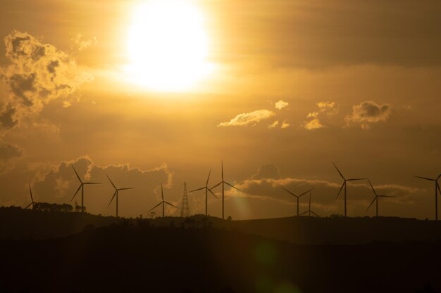 Photo silhouettes of wind turbines farm on mountains in rural areas