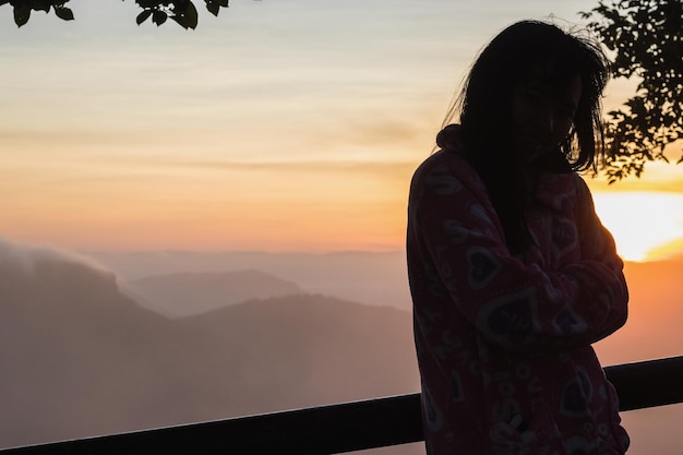 Silhouettes of woman on the mountian at sunrise