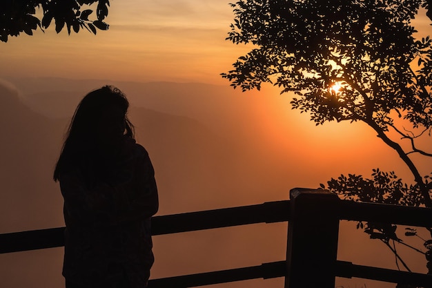 Silhouettes of woman on the mountian at sunrise