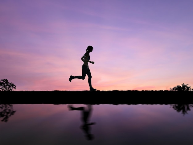 Silhouetvrouw joggen met twilight sky background