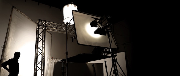 Silhoutte images of video production and lighting set for filming which movie crew team working