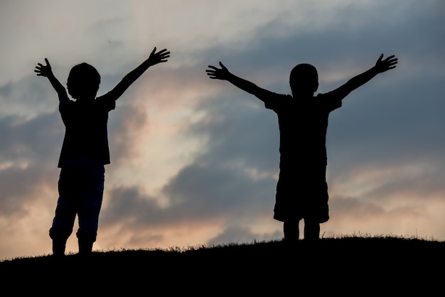 Foto silhoutte van twee broers die van de vrijheid genieten