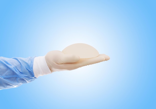 Silicone breast implant on hands Doctor tries on silicone breastsxA